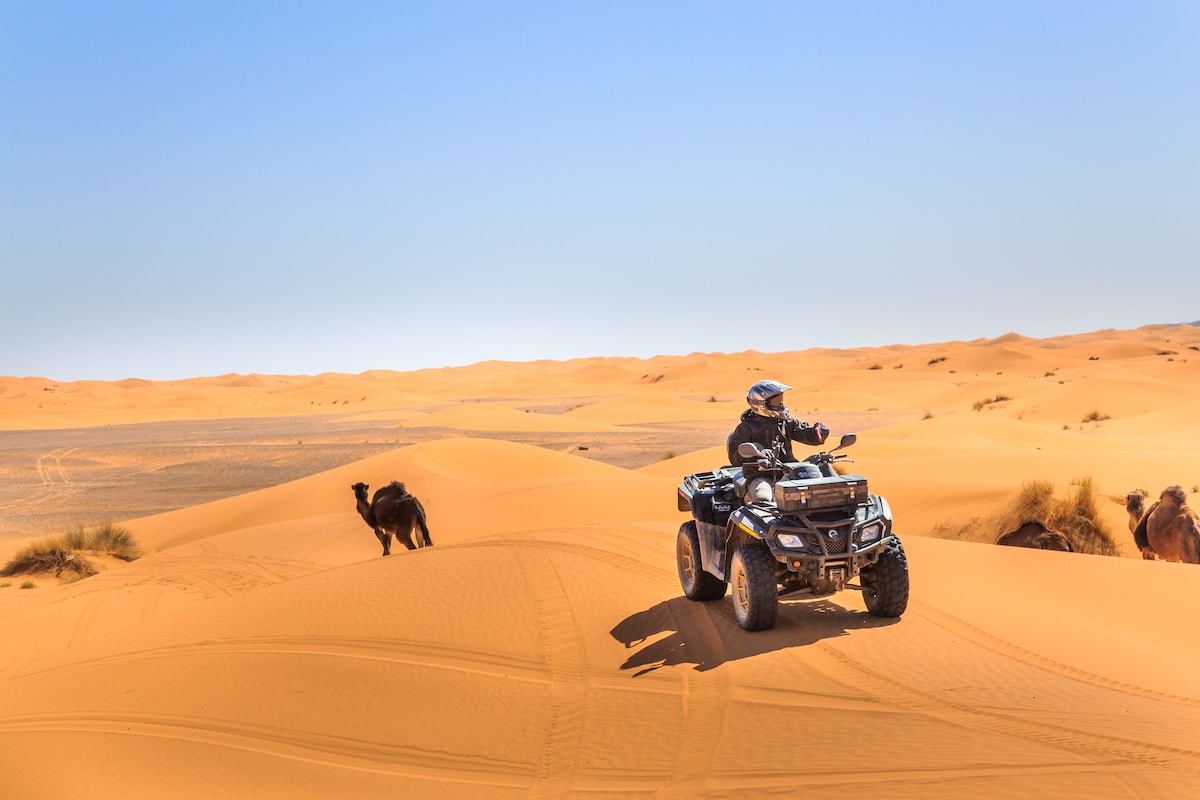 Vue panoramique du désert du Sahara au coucher du soleil avec un groupe de voyageurs marocains partant de Casablanca